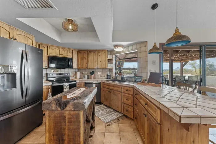 Modern and efficient—everything you need to create a delicious meal. The kitchen features a stainless steel refrigerator, stove, coffee maker, kitchenette oven, kettle, and blender.