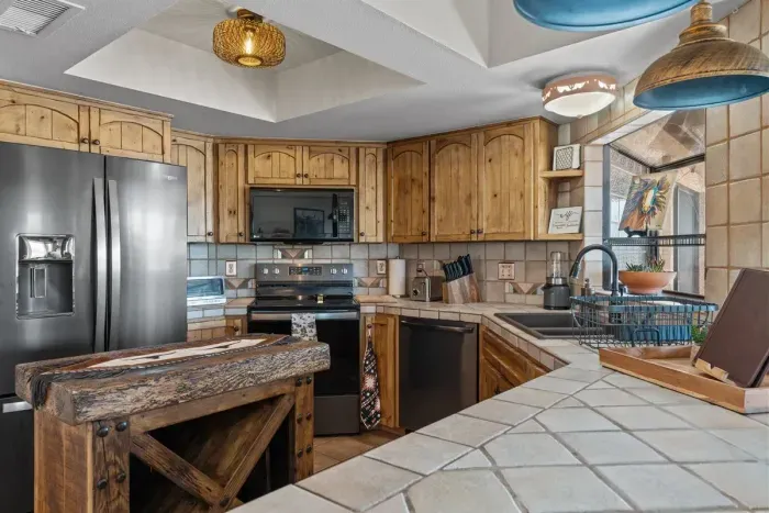 Modern and efficient—everything you need to create a delicious meal. The kitchen features a stainless steel refrigerator, stove, coffee maker, kitchenette oven, kettle, and blender.