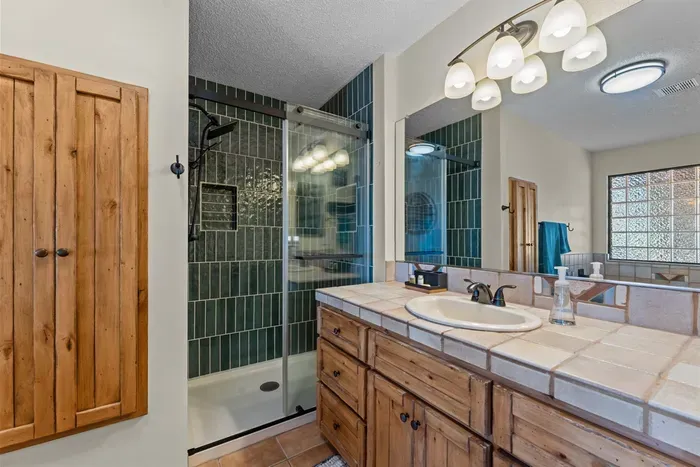 Unwind in this serene bathroom featuring a deep soaking tub, modern walk-in shower, and sunlit privacy. Plush towels and warm wooden accents complete the spa-like vibe, perfect for a restful escape.
