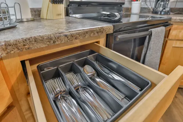 Fully equipped and modern—our kitchen includes essential electronics and utensils, featuring a stainless steel refrigerator, stove, coffee maker, and a full set of cookware and tableware