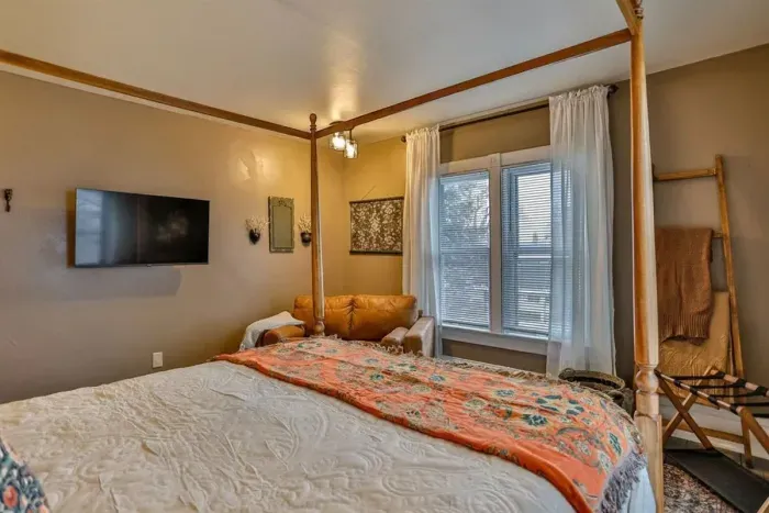 Enjoy a peaceful night’s sleep with thoughtful vintage touches, hardwood floors, and a wall-mounted TV for added comfort.