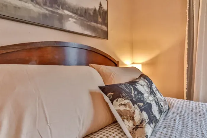 Bright and inviting bedroom with a comfortable bed, soft linens, and warm wood accents.