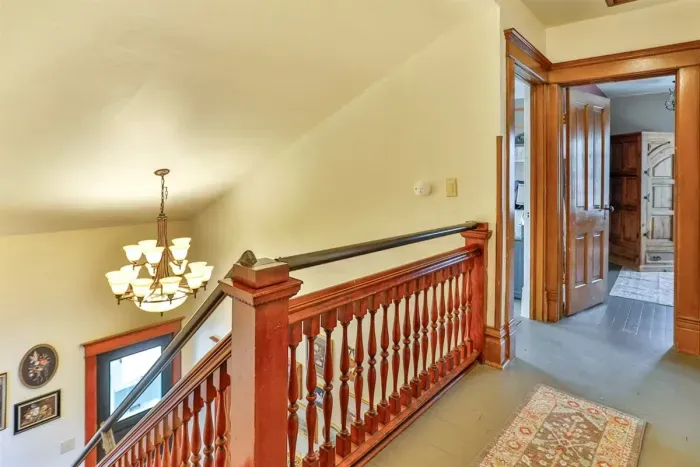 A classic wooden staircase connects the floors, showcasing the home’s original character and timeless charm that adds to its cozy, authentic feel.