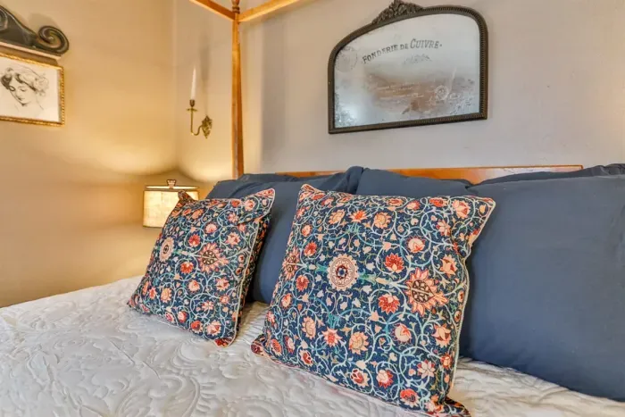 Charming, serene bed, plush linens, and warm ambient lighting.