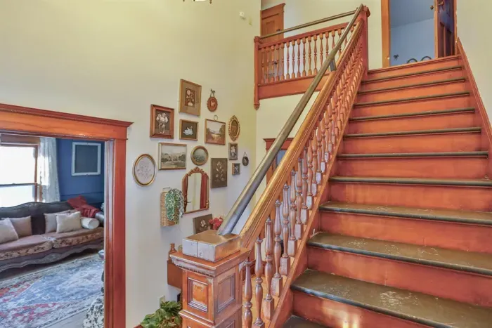 A classic wooden staircase connects the floors, highlighting the home’s original character and timeless charm while enhancing its warm, inviting feel.