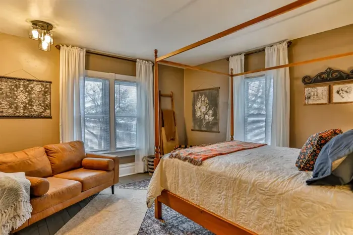 Charming, serene bedroom featuring a classic four-poster bed, plush linens, and warm ambient lighting.