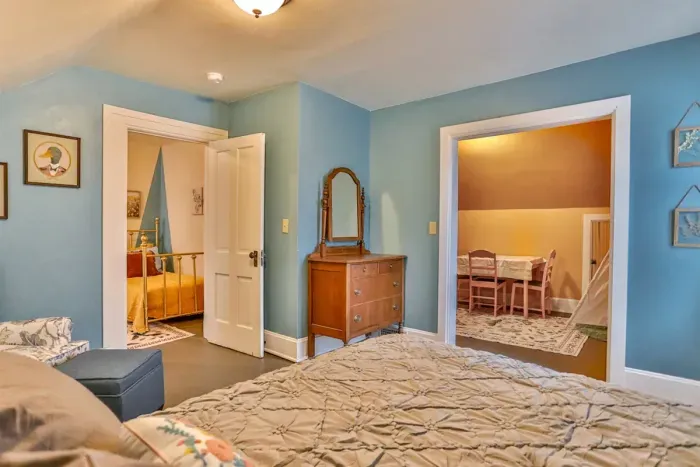 Kid's bedroom with soft blue walls, a comfortable bed, and warm lighting.
