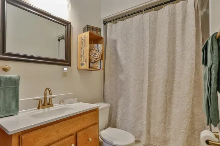 Clean and comfortable bathroom with a modern vanity, fresh linens, with thoughtful touches and warm lighting
