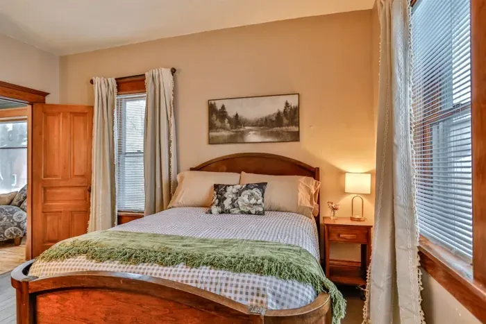 Bright and inviting bedroom with a comfortable bed, soft linens, and warm wood accents.