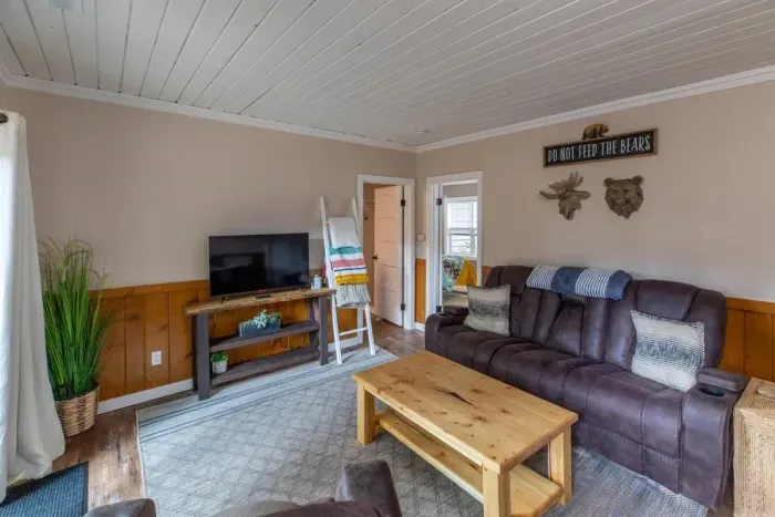 Indulge in comfort and style in our living room, featuring plush sofas, elegant chairs, and a spacious eating area. Unwind with entertainment on the TV. 