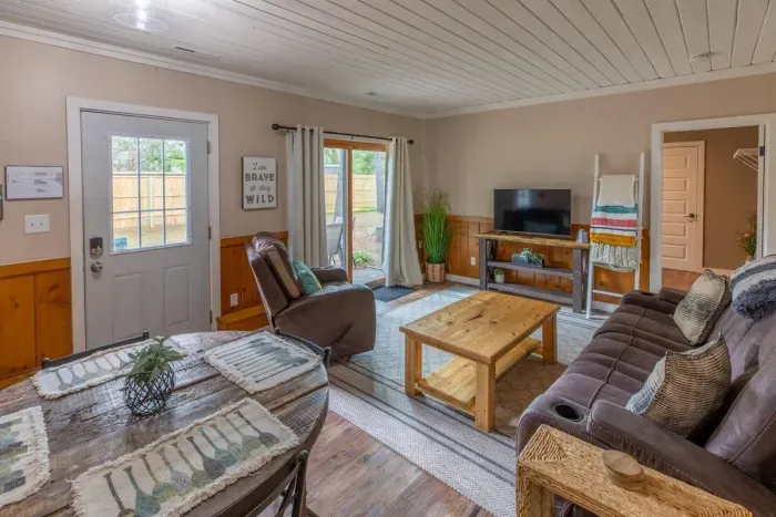 Indulge in comfort and style in our living room, featuring plush sofas, elegant chairs, and a spacious eating area. Unwind with entertainment on the TV. 