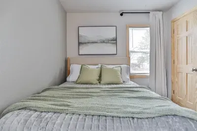 Spacious bedroom with soft pillows, cool air, and a calm, inviting setting.