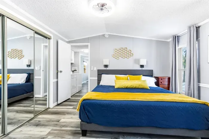 Bright, modern bedroom with a cozy queen-size bed, soft linens, and a calming blue-and-yellow accent palette.