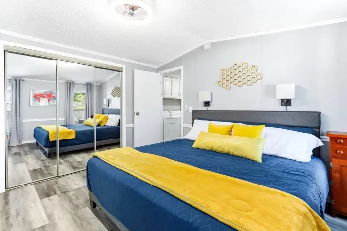 Cozy bedroom with large mirror, natural light, and en-suite.