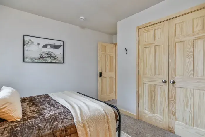 Simple yet stylish bedroom with comfortable bed, fresh air, and a homey feel.