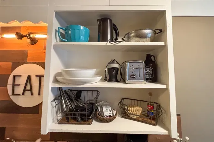 Modern and efficient—everything you need to create a delicious meal. The kitchen features a stainless steel refrigerator, stove, coffee maker, kitchenette oven, kettle, and blender