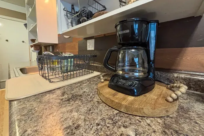 Modern and efficient—everything you need to create a delicious meal. The kitchen features a stainless steel refrigerator, stove, coffee maker, kitchenette oven, kettle, and blender