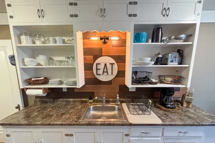 Modern and efficient—everything you need to create a delicious meal. The kitchen features a stainless steel refrigerator, stove, coffee maker, kitchenette oven, kettle, and blender