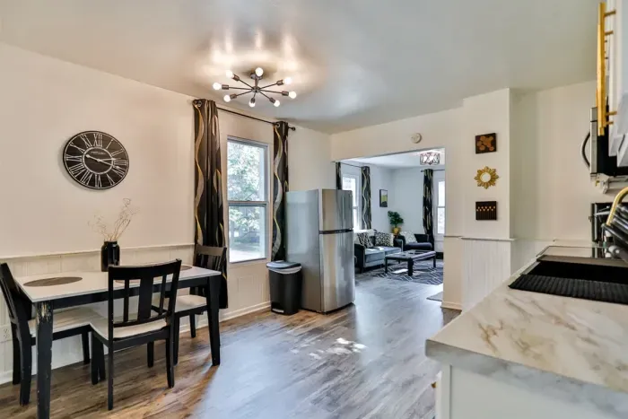 A modern kitchen equipped with high-end appliances and ample lighting. It has a coffee maker, oven, stove top, utensils, and all it takes to fix a delicious meal.