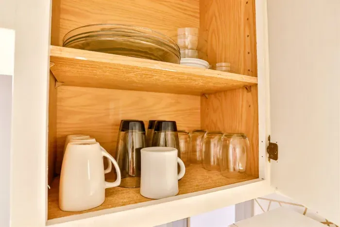 A modern kitchen equipped with high-end appliances and ample lighting. It has a coffee maker, oven, stove top, utensils, and all it takes to fix a delicious meal.