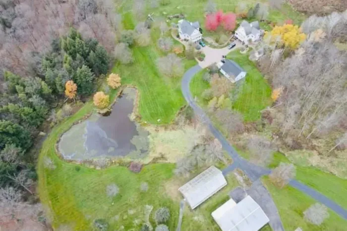 An aerial view of the property showcasing its charming layout, and surrounding greenery. This perspective highlights the home’s welcoming setting and peaceful atmosphere, offering guests a clear sense of the space and its inviting surroundings.