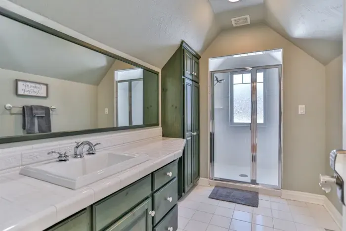 Enjoy a private bathroom with a sink and functional cabinetry below, combining practicality with comfort.