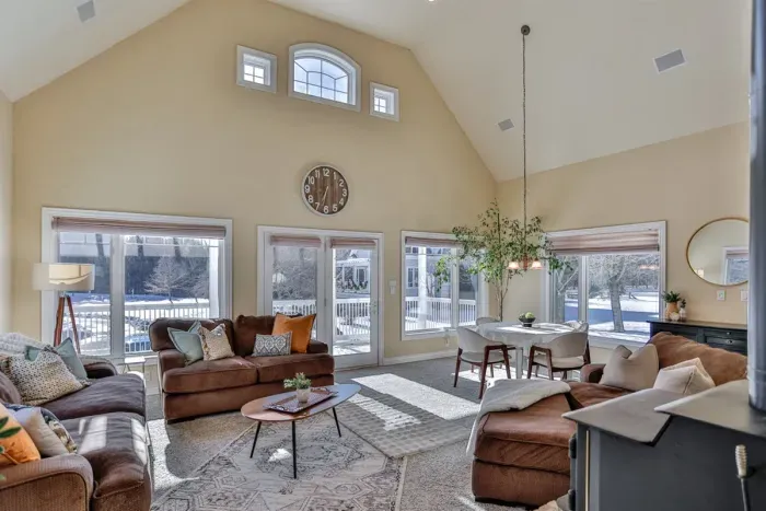 This shared living space combines a bright living room with large windows, a comfy couch, and a dining area designed for comfort, conversation, and convenience.