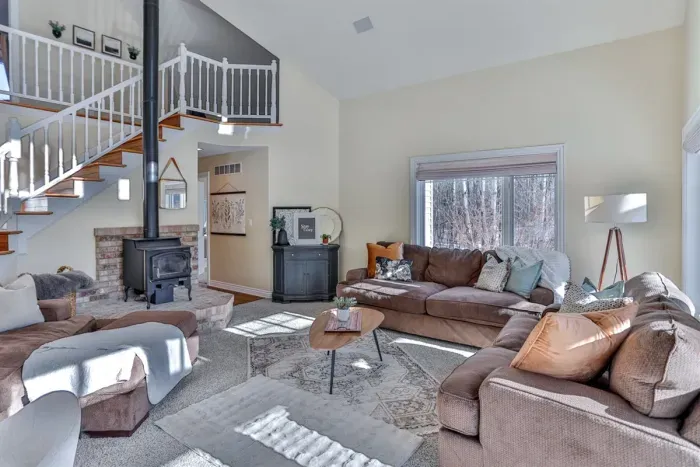 A spacious shared living area with a cozy couch, a dining area, and easy access to the stairs, creating a welcoming space for both lounging and moving between floors.