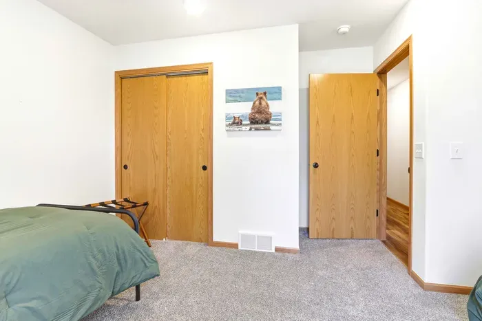 Perfect for easy shared stays, this bright bedroom offers two cozy beds and a peaceful connection to the trees.