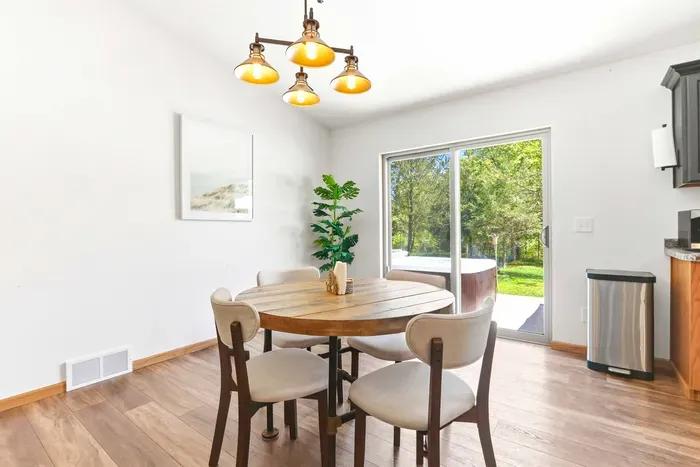 Enjoy slow breakfasts and easy dinners in a bright dining nook that opens to the patio, hot tub, and peaceful wooded views.