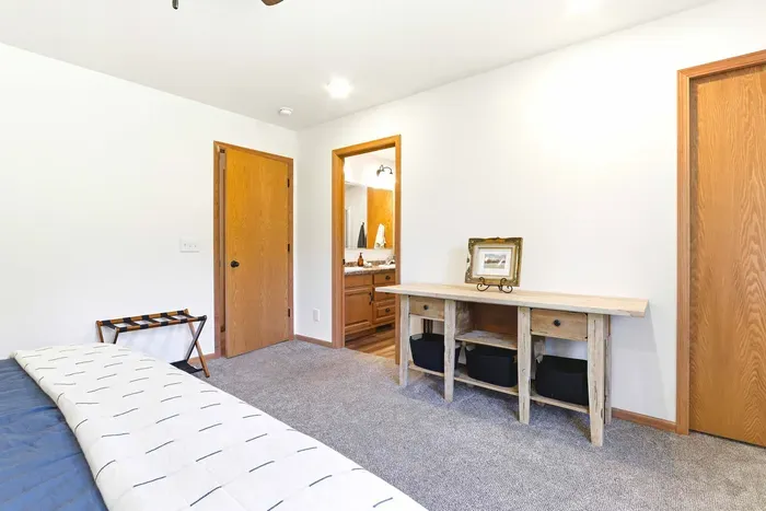 Settle into a restful bedroom with convenient ensuite access, soft textures, and a simple workspace for quiet moments between adventures.