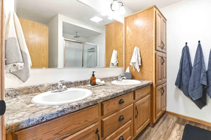 Get ready with ease in a spacious double-vanity bath with warm wood finishes and plenty of room to refresh.