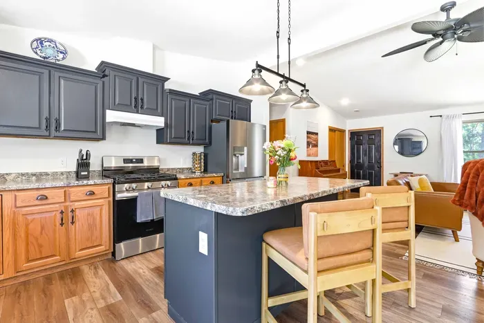Cook, sip, and connect in a stylish open kitchen with generous island seating and a warm flow into the living space.