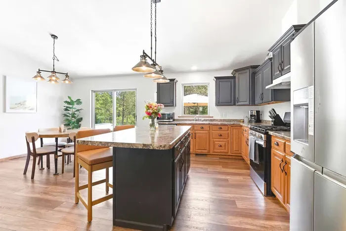 Cook and gather with ease in a bright kitchen featuring a spacious island, warm finishes, and peaceful views outside.