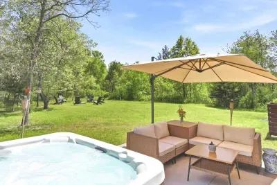 Unwind in a private backyard retreat with a bubbling hot tub, shaded lounge seating, and peaceful green views made for slow mornings and starlit evenings.