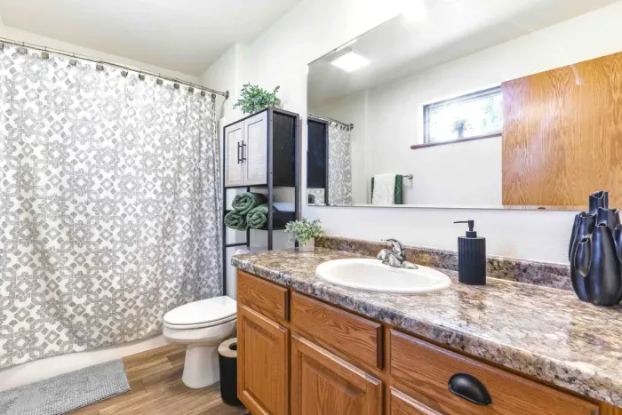 Refresh with ease in a bright, well-kept bathroom featuring warm finishes and simple, thoughtful comforts.