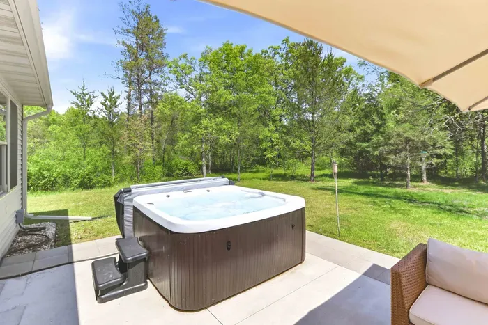 Slip into a soothing hot tub retreat with shaded lounge seating and peaceful wooded views all around.