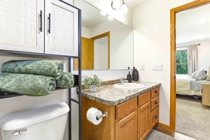 Enjoy an easy refresh in a tidy ensuite bath with soft towels, warm finishes, and convenient access from the bedroom.