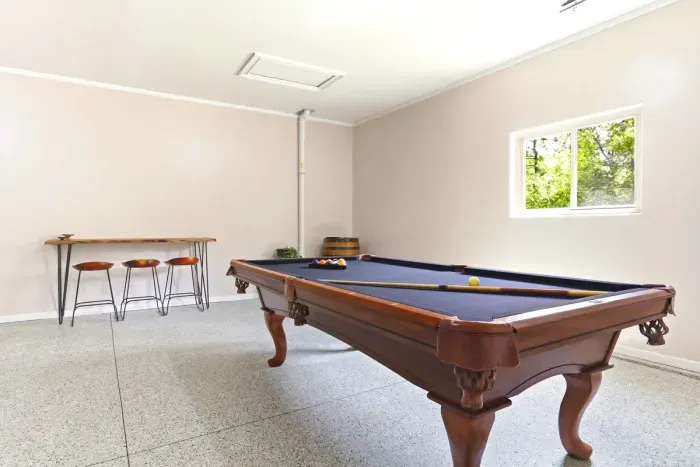 Turn downtime into friendly competition in a bright game room with a classic pool table and relaxed bar seating.