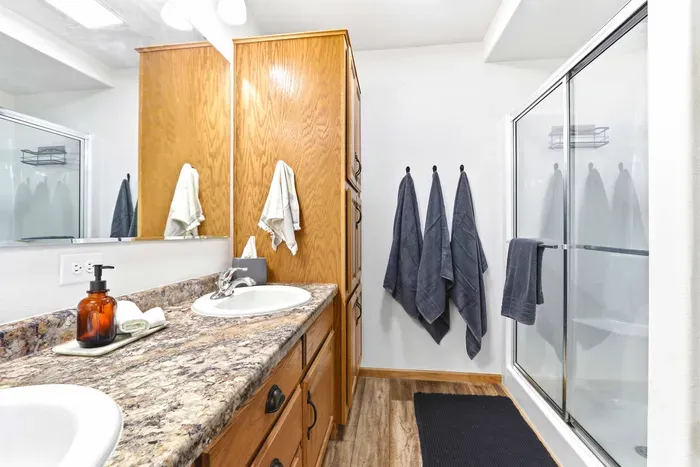 Start the day smoothly in a bright ensuite bathroom with dual sinks, generous storage, and relaxed everyday comfort.