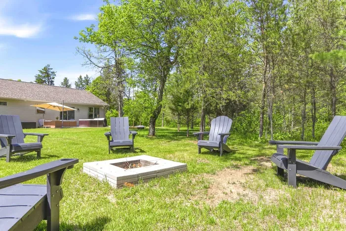 Gather under the trees for relaxed evenings by the fire pit, with the hot tub and patio just steps away.