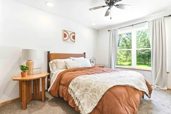 Ease into restful mornings in a bright, cozy bedroom with soft linens and serene views of the surrounding greenery.
