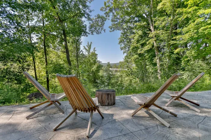 Unwind on the outdoor patio seating surrounded by lush trees and peaceful scenic views.