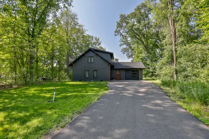 Arrive to a peaceful wooded retreat with a private driveway and modern cabin charm.