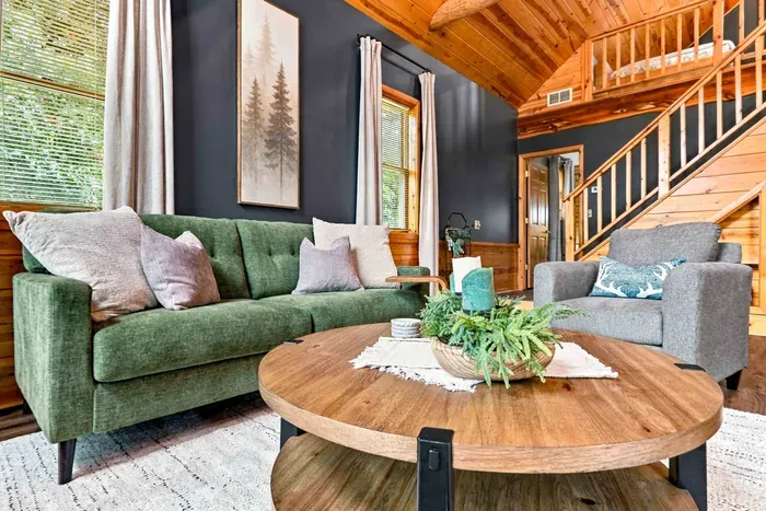 Unwind in style on the plush green sofa or cozy armchair, gathering around the rustic coffee table under soaring vaulted ceilings.