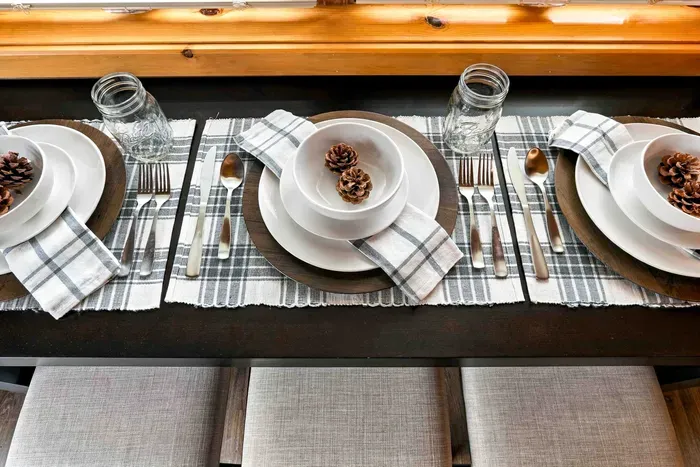 Savor cozy meals together at this dining table with padded stool seating, perfectly set beside bright windows for scenic views while you eat.