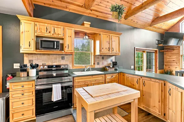 Whip up delicious meals in this rustic kitchen featuring a stainless steel oven, built-in microwave, center prep kitchen island, and a coffee station.