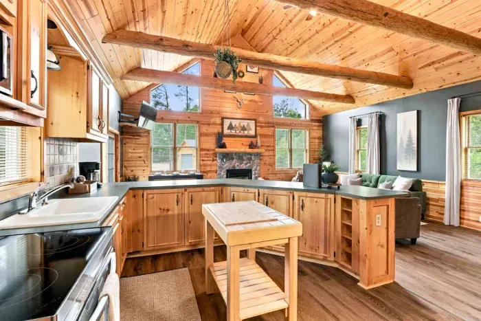 Cook with ease in this warm, log-accented kitchen equipped with a stove and oven, microwave, coffee maker, and a convenient center prep island.