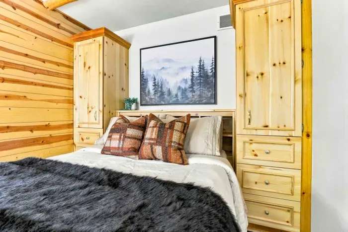 Unwind in a rustic-chic bedroom complete with a cozy bed, integrated wardrobe cabinets.