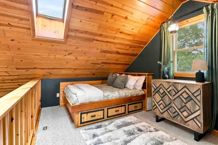 Unwind in this charming loft space featuring plush twin beds, integrated storage drawers, and a rustic dresser.